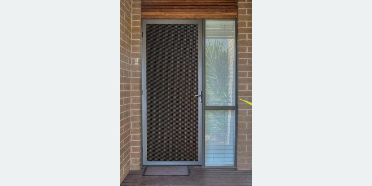 Installed round-hole alloy security mesh in a door or window frame