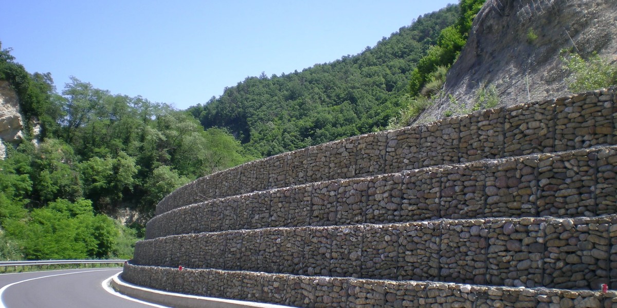 Stone-filled woven gabion mesh retaining wall